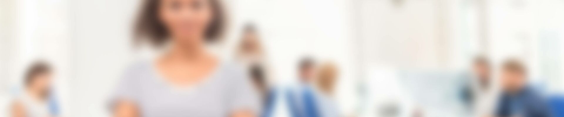 Mitarbeiterin steht in einem Großraumbüro